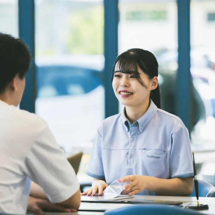 写真：女性社員が店舗に来店したお客様と商談している様子