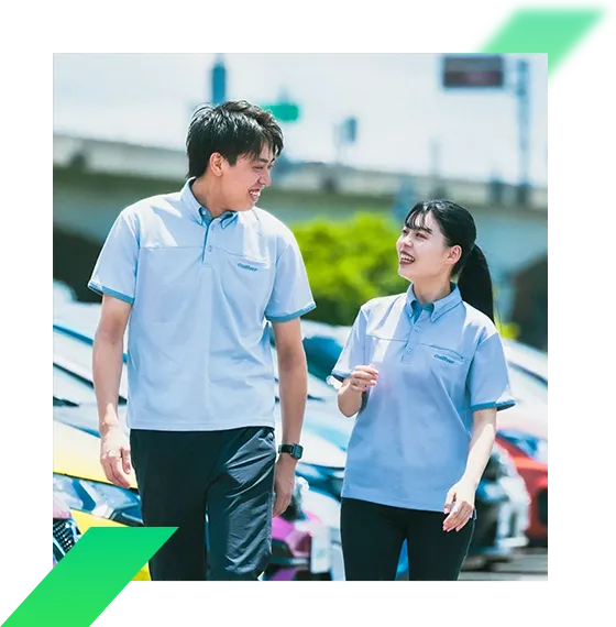 写真：男性と女性社員が店舗の駐車場で談笑している様子